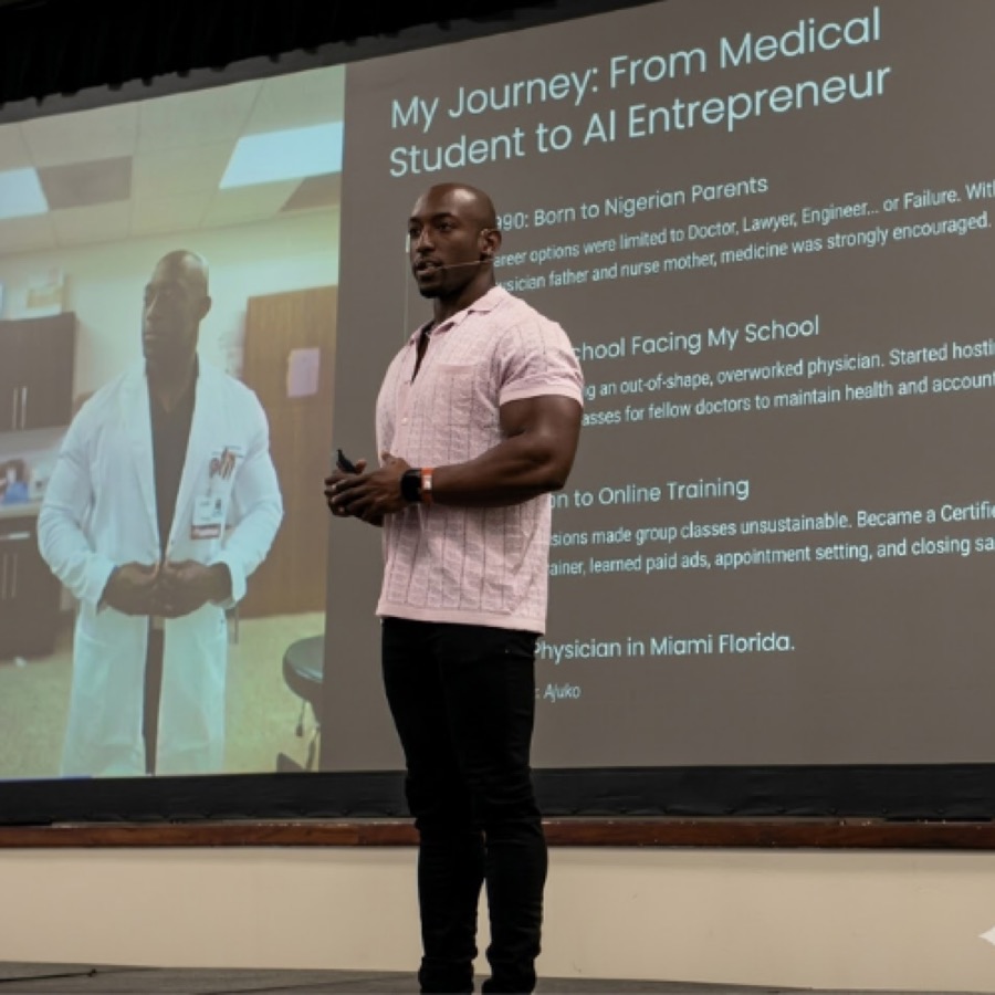 Dr. Emeka Ajufo speaking on stage in front of a slide reading “My Journey: From Medical Student to AI Entrepreneur”